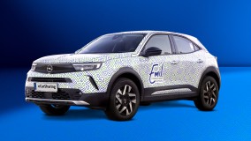 Opel Mokka-e mit Emil eCarSharing-Branding und grün-blauem Muster.