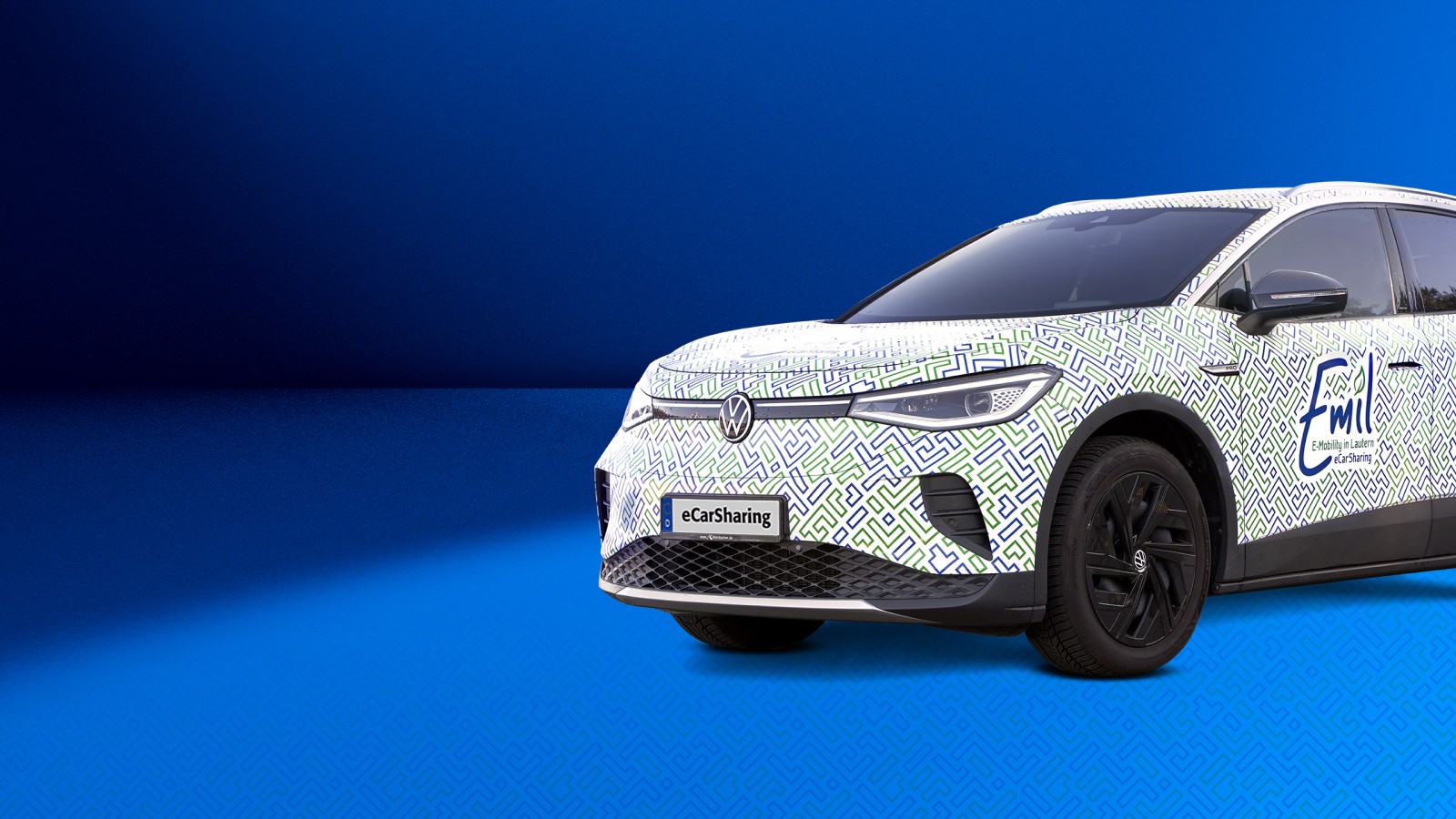 VW ID.4 mit Emil eCarSharing-Branding auf blauem Hintergrund ragt rechts bis zu Hälfte ins Bild hinein. 